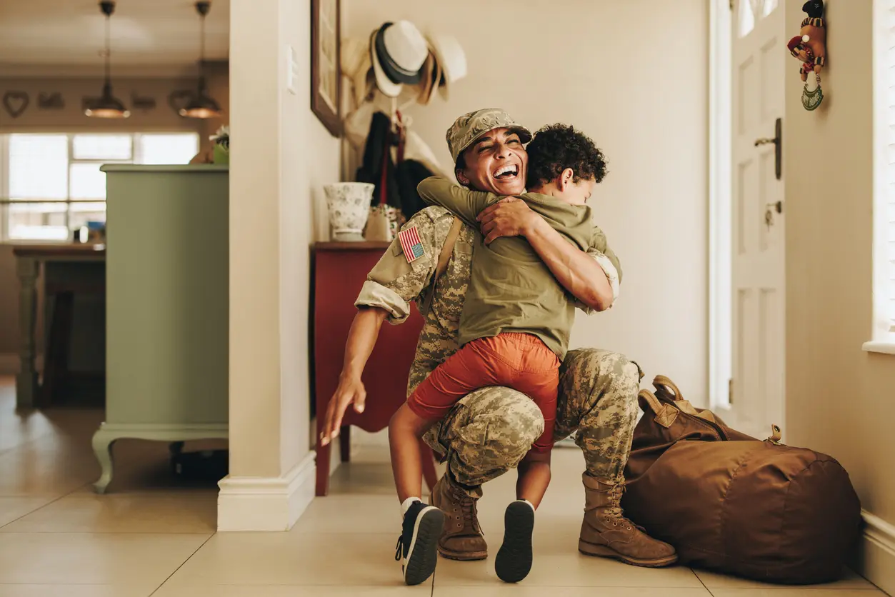 Military member hugs child upon return home.