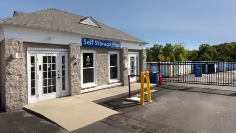 Self Storage Plus small office building with a security gate in front.