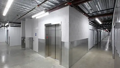 Indoor storage units with elevator at the end of the hallway.