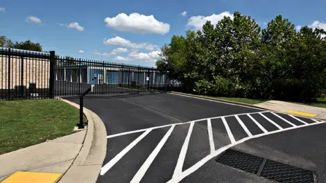 Security gate with key code box on a nicely paved road.