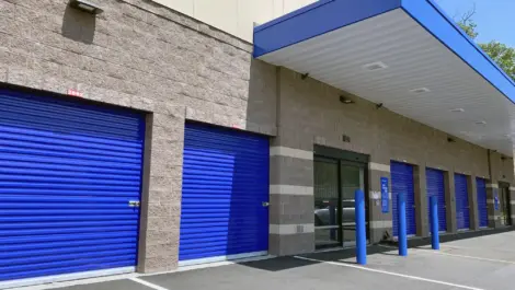 Drive up storage units with bright blue doors.