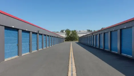 Outdoor storage units on both sides of paved alleyway.