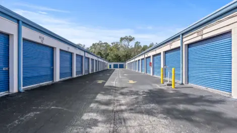 View of storage units with arrows pointing in the direction of traffic on the paved road between.