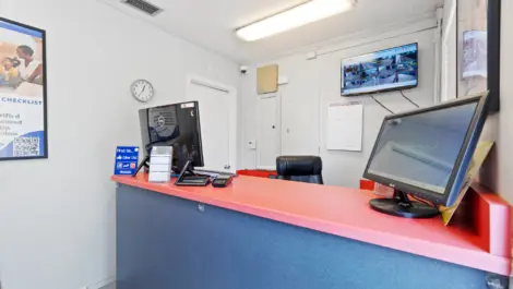 Front office of storage facility with secuity footage on the tv in the background.