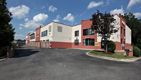 Red and white storage facility building with a security gate in the front.