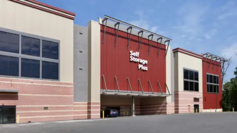 Front of Self Storage Plus red and tan facility building.