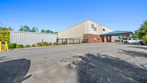 Zoomed out image of storage facility showing their parking area in front of building.