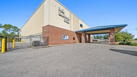 Self Storage Plus tan building with an overhead entrance.