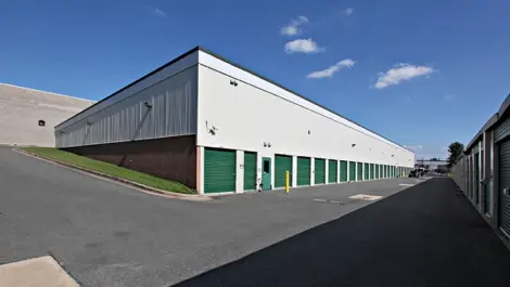 Back end of storage facility with green doors.