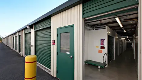 Up close view of inside of storage facility with green doors.